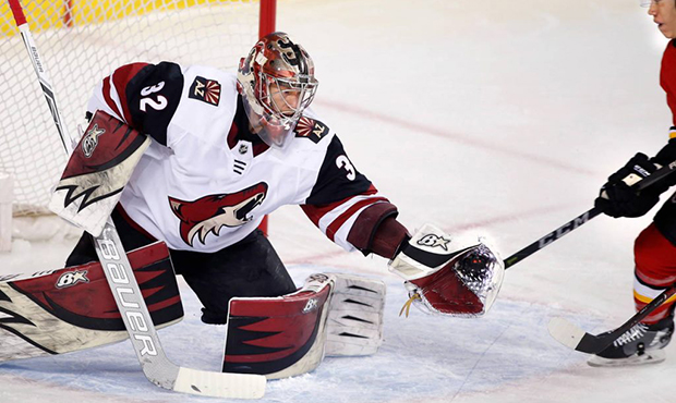 Arizona Coyotes goalie Antti Raanta from Finland, makes a save in front of Calgary Flames' Spencer ...