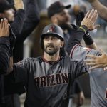 Arizona Diamondbacks' Daniel Descalso, center, is congratulated in the dugout for his two-run home run during the seventh inning of the team's baseball game against the Los Angeles Dodgers, Friday, April 13, 2018, in Los Angeles. (AP Photo/Jae C. Hong)