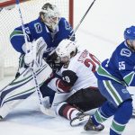 Arizona Coyotes' Dylan Strome (20) crashes into Vancouver Canucks goalie Jacob Markstrom, of Sweden, behind Alex Biega (55) during the second period of an NHL hockey game Thursday, April 5, 2018, in Vancouver, British Columbia. (Darryl Dyck/The Canadian Press via AP)