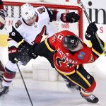 Calgary Flames' Garnet Hathaway (right) is knocked down by Arizona Coyotes' Trevor Murphy in front of the Arizona net during second period NHL hockey action in Calgary, Alberta, Tuesday, April 3, 2018. (Larry MacDougal/The Canadian Press via AP)