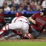 Arizona Diamondbacks' A.J. Pollock, right, is tagged out at home plate by Philadelphia Phillies' Andrew Knapp after Jarrod Dyson hit a fielders choice during the fourth inning of a baseball game, Wednesday, April 25, 2018, in Philadelphia. (AP Photo/Derik Hamilton)