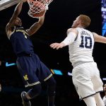 Michigan guard Charles Matthews, left, dunks the ball over Villanova guard Donte DiVincenzo during the first half in the championship game of the Final Four NCAA college basketball tournament, Monday, April 2, 2018, in San Antonio. (AP Photo/David J. Phillip)