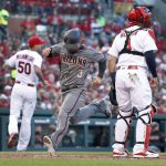 Arizona Diamondbacks' Daniel Descalso (3) scores between St. Louis Cardinals starting pitcher Adam Wainwright, left, and catcher Yadier Molina during the second inning of a baseball game Thursday, April 5, 2018, in St. Louis. (AP Photo/Jeff Roberson)