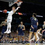 Villanova guard Donte DiVincenzo dunks the ball over Michigan guard Charles Matthews, left, during the first half in the championship game of the Final Four NCAA college basketball tournament, Monday, April 2, 2018, in San Antonio. (AP Photo/Eric Gay)