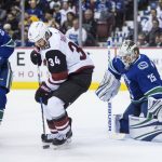 Arizona Coyotes' Zac Rinaldo (34) looks for the puck in front of Vancouver Canucks goalie Jacob Markstrom (25), of Sweden, as Alex Biega, left, watches during the first period of an NHL hockey game Thursday, April 5, 2018, in Vancouver, British Columbia. (Darryl Dyck//The Canadian Press via AP)