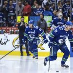 Vancouver Canucks' Henrik Sedin, left, and his twin brother, Daniel Sedin, both of Sweden, skate before their final home NHL hockey game, against the Arizona Coyotes, Thursday, April 5, 2018, in Vancouver, British Columbia. The Sedins are retiring after the season. (Darryl Dyck/The Canadian Press via AP)