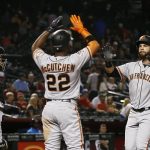 San Francisco Giants' Brandon Belt, right, celebrates his two-run home run with Andrew McCutchen (22), while Arizona Diamondbacks catcher Alex Avila, left, stands at home plate during the 10th inning of a baseball game Wednesday, April 18, 2018, in Phoenix. (AP Photo/Ross D. Franklin)