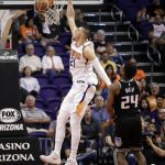 Phoenix Suns center Alex Len (21) dunks as Sacramento Kings guard Buddy Hield (24) looks on during the first half of an NBA basketball game Tuesday, April 3, 2018, in Phoenix. (AP Photo/Matt York)