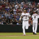 Arizona Diamondbacks' A.J. Pollock (11) rounds the bases after celebrating his home run against the Los Angeles Dodgers with third base coach Tony Perezchica (8) during the second inning of a baseball game Monday, April 30, 2018, in Phoenix. (AP Photo/Ross D. Franklin)