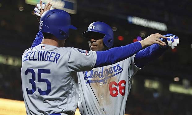 Los Angeles Dodgers' Cody Bellinger, left, and Yasiel Puig (66) celebrate after scoring against the...