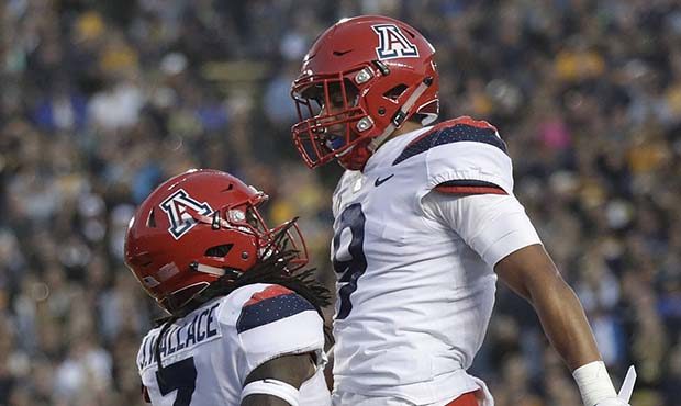Arizona safety Jarrius Wallace, left, celebrates after intercepting a pass in the end zone with tea...