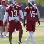 Arizona Cardinals' Christian Kirk (13) and Rashad Ross (15) walk in the field during an organized team activity at the NFL football team's training facility, Tuesday, May 15, 2018, in Tempe, Ariz.  Kirk took the field Tuesday for the first time since a report surfaced about his arrest in the months before the team chose him in the second round of the NFL draft. (AP Photo/Matt York)