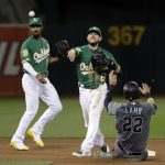 Oakland Athletics second baseman Jed Lowrie, center, completes a double play after forcing out Arizona Diamondbacks' Jake Lamb (22) on a grounder by Ketel Marte during the seventh inning of a baseball game Friday, May 25, 2018, in Oakland, Calif. (AP Photo/Marcio Jose Sanchez)