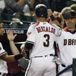 Arizona Diamondbacks' Daniel Descalso (3) celebrates his run scored against the Milwaukee Brewers with David Peralta, left, and manager Torey Lovullo (17) during the fourth inning of a baseball game Monday, May 14, 2018, in Phoenix. (AP Photo/Ross D. Franklin)