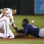 Milwaukee Brewers' Lorenzo Cain (6) gets hit with a throw as he steals second base as Arizona Diamondbacks shortstop Nick Ahmed, left, is unable to make the catch during the first inning of a baseball game Wednesday, May 16, 2018, in Phoenix. (AP Photo/Ross D. Franklin)