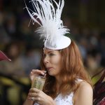 Stephanie Hrin, of Virginia drinks a Black-eyed Susan in the grandstand area ahead of the 143rd Preakness Stakes horse race at Pimlico race course, Saturday, May 19, 2018, in Baltimore. (AP Photo/Nick Wass)