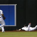 Arizona Diamondbacks center fielder Chris Owings, right, dives in vain for a double by Milwaukee Brewers' Christian Yelich as right fielder David Peralta (6) backs up the play during the fourth inning of a baseball game Tuesday, May 15, 2018, in Phoenix. (AP Photo/Ross D. Franklin)