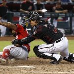 Arizona Diamondbacks catcher John Ryan Murphy, right, tags out Washington Nationals' Howie Kendrick, left, as Kendrick tries to score on a bunt during the fifth inning of a baseball game Saturday, May 12, 2018, in Phoenix. (AP Photo/Ross D. Franklin)