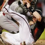 Arizona Diamondbacks' Chris Owings, right, scores a run under the tag by Cincinnati Reds catcher Tucker Barnhart on a ball hit by Nick Ahmed in the fourth inning during a baseball game, Monday, May 28, 2018, in Phoenix. (AP Photo/Rick Scuteri)