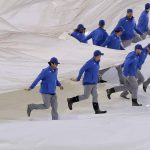 The New York Mets grounds crew pulls the tarp off the field after a rain delay before a baseball game between the New York Mets and the Arizona Diamondbacks, Saturday, May 19, 2018, in New York. (AP Photo/Julie Jacobson)