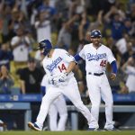 Los Angeles Dodgers' Enrique Hernandez, left, is congratulated by third base coach Chris Woodward after hitting the game-tying solo home run during the ninth inning of a baseball game against the Arizona Diamondbacks in Los Angeles, Tuesday, May 8, 2018. (AP Photo/Kelvin Kuo)