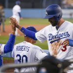 Los Angeles Dodgers' Chris Taylor, right, celebrates with bench coach Bob Geren, left, after scoring on an RBI single by Matt Kemp, as manager Dave Roberts watches during the first inning of a baseball game against the Arizona Diamondbacks in Los Angeles, Tuesday, May 8, 2018. (AP Photo/Kelvin Kuo)