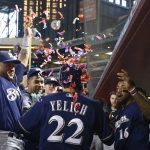 Milwaukee Brewers' Christian Yelich (22) celebrates his two-run home run against the Arizona Diamondbacks with Domingo Santana (16), Hernan Perez, left, and other teammates during the second inning of a baseball game Wednesday, May 16, 2018, in Phoenix. (AP Photo/Ross D. Franklin)