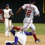 Arizona Diamondbacks relief pitcher Andrew Chafin, bottom, avoids a collision with Washington Nationals' Howie Kendrick (12) after Chafin beat Kendrick to first base for an out as Diamondbacks shortstop Ketel Marte, back left, looks on during the 11th inning of a baseball game Thursday, May 10, 2018, in Phoenix. The Nationals defeated the Diamondbacks 2-1. (AP Photo/Ross D. Franklin)