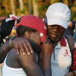 Daudi Abe, right, embraces his daughter, Alabama golfer Lakareber Abe, after Arizona defeated Alabama during the final round of the NCAA Division I women's golf championships in Stillwater, Okla., Wednesday, May 23, 2018. (AP Photo/Sue Ogrocki)
