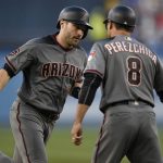 Arizona Diamondbacks' A.J. Pollock celebrates with third base coach Tony Perezchica after hitting a two-run home run off Los Angeles Dodgers starting pitcher Rich Hill during the first inning of a baseball game in Los Angeles, Tuesday, May 8, 2018. (AP Photo/Kelvin Kuo)