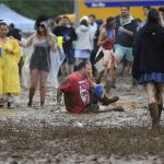 A man falls on a muddy infield during the 143rd Preakness Stakes horse race at Pimlico race course, Saturday, May 19, 2018, in Baltimore. (AP Photo/Nick Wass)