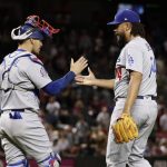 Los Angeles Dodgers relief pitcher Kenley Jansen, right, greets catcher Yasmani Grandal after a baseball game against the Arizona Diamondbacks on Wednesday, May 2, 2018, in Phoenix. The Dodgers won 2-1. (AP Photo/Matt York)