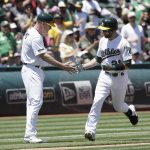 Oakland Athletics' Jonathan Lucroy, right, is congratulated by third base coach Matt Williams after hitting a home run against the Arizona Diamondbacks during the third inning of a baseball game in Oakland, Calif., Sunday, May 27, 2018. (AP Photo/Jeff Chiu)