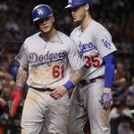 Los Angeles Dodgers' Alex Verdugo (61) celebrates with Cody Bellinger (35) after scoring on a sacrifice by Yasmani Grandal during the eighth inning of a baseball game Wednesday, May 2, 2018, in Phoenix against the Arizona Diamondbacks. (AP Photo/Matt York)