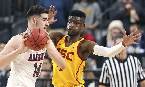 Arizona's Dusan Ristic, left, looks to pass the ball as Southern California's Chimezie Metu defends...