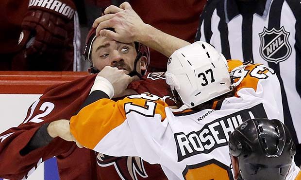 Philadelphia Flyers' Jay Rosehill (37) gives Phoenix Coyotes' Paul Bissonnette, left, a hand to the...