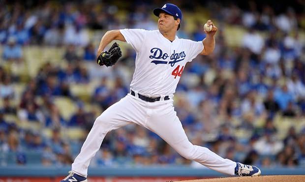 Los Angeles Dodgers starting pitcher Rich Hill throws to the plate during the first inning of a bas...