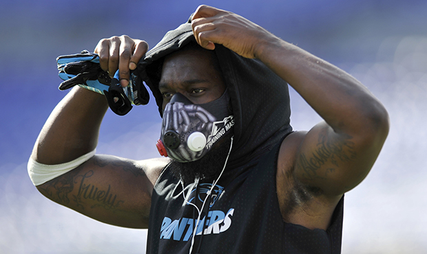 Carolina Panthers defensive back Travell Dixon wears a training mask during warmups before an NFL p...