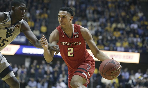 Texas Tech guard Zhaire Smith (2) drives while defended by West Virginia forward Lamont West (15) d...