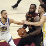 Cleveland Cavaliers' LeBron James (23) is defended by Golden State Warriors' Klay Thompson and Stephen Curry (30) during the first half of Game 4 of basketball's NBA Finals, Friday, June 8, 2018, in Cleveland. (AP Photo/Carlos Osorio)