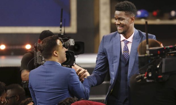 Arizona's Deandre Ayton, right, is congratulated by friends and family after he was picked first ov...