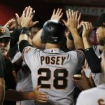 San Francisco Giants' Buster Posey (28) is congratulated after scoring against the Arizona Diamondbacks during the second inning of a baseball game Friday, June 29, 2018, in Phoenix. (AP Photo/Ross D. Franklin)