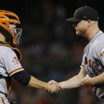 San Francisco Giants relief pitcher Will Smith, right, shakes hands with catcher Buster Posey after the team's 2-1 win in a baseball game against the Arizona Diamondbacks on Friday, June 29, 2018, in Phoenix. (AP Photo/Ross D. Franklin)