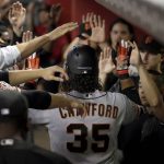 San Francisco Giants' Brandon Crawford (35) is greeted in the dugout after hitting a solo home run against the Arizona Diamondbacks during the second inning of a baseball game Saturday, June 30, 2018, in Phoenix. (AP Photo/Matt York)