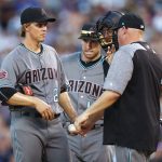 Arizona Diamondbacks starting pitcher Zack Greinke confers with first baseman Paul Goldschmidt, catcher Jeff Mathis and pitching coach Mike Butcher, from left, after Greinke gave up a single to Colorado Rockies' Gerardo Parra during the fifth inning of a baseball game Friday, June 8, 2018, in Denver. (AP Photo/David Zalubowski)