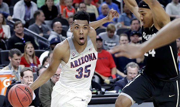 Arizona's Allonzo Trier (35) drives past Colorado's George King (24) during the first half of an NC...