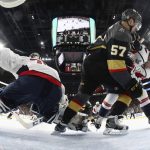 Vegas Golden Knights left wing David Perron, center, tussles with Washington Capitals defenseman Christian Djoos, right, before scoring on Capitals goaltender Braden Holtby during the second period in Game 5 of the NHL hockey Stanley Cup Finals on Thursday, June 7, 2018, in Las Vegas. (Harry How/Pool via AP)