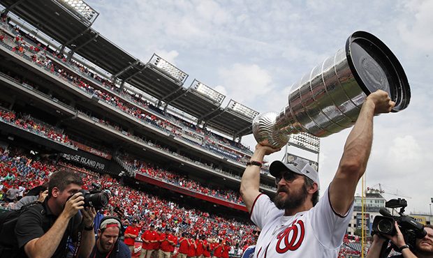 Washington Capitals' Alex Ovechkin, from Russia, lifts the Stanley Cup on the field before a baseba...