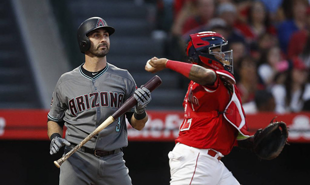 Arizona Diamondbacks' Daniel Descalso, left, starts to head to the dugout after striking out as Los...