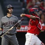 Arizona Diamondbacks' Daniel Descalso, left, starts to head to the dugout after striking out as Los Angeles Angels catcher Martin Maldonado throws the ball to third base during the third inning of a baseball game, Tuesday, June 19, 2018, in Anaheim, Calif. (AP Photo/Jae C. Hong)